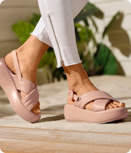 Hoge roze platform sandalen die belopen worden op het hout