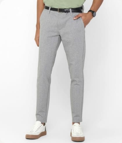 Man met grijs gestreepte chino en nette witte schoenen eronder
