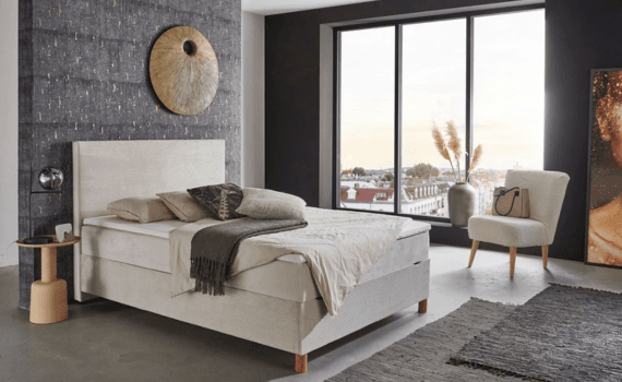 Een moderne slaapkamer met een witte boxspring