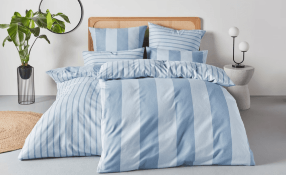 Een bed met blauw gestreepte overtrek