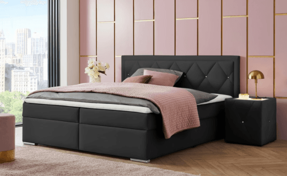 Slaapkamer die roze ingericht is met een zwarte boxspring