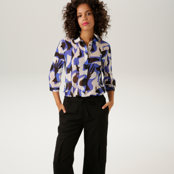 Vrouw met een gekleurde blouse en een zwarte cargobroek