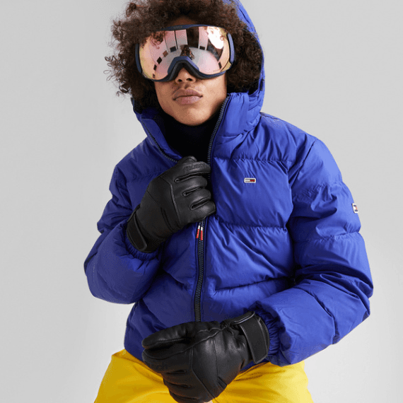 Man met grote blauwe ski-jas aan en een skibril op 