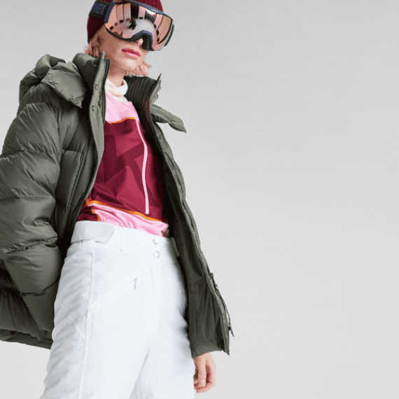 Vrouw met een witte skibroek aan en een skibril op