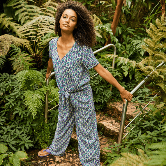 Vrouw die in de natuur staat met een blauw gekleurd jumpsuit aan