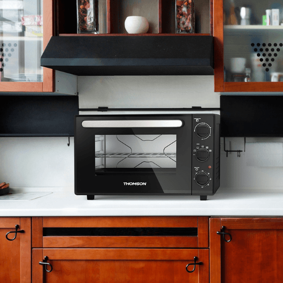 Een mobiele kleine oven die op het aanrecht staat in de keuken