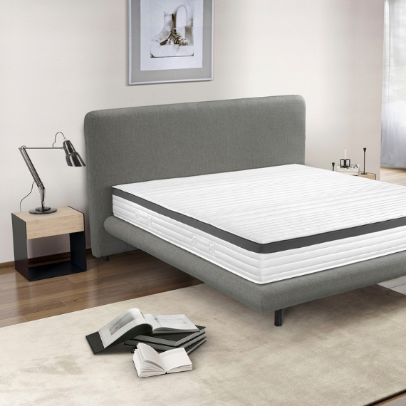 Slaapkamer met een bed dat niet is opgemaakt en boeken op de grond