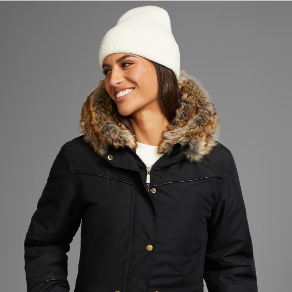 Vrouw met een winterjas aan en een witte muts op