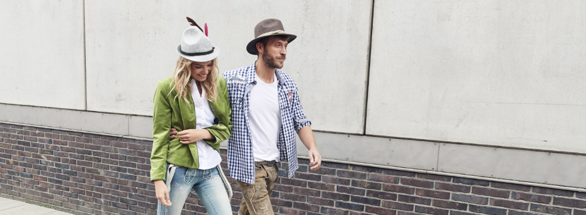 Man en vrouw gekleed in Oktoberfest kleding lopend op straat