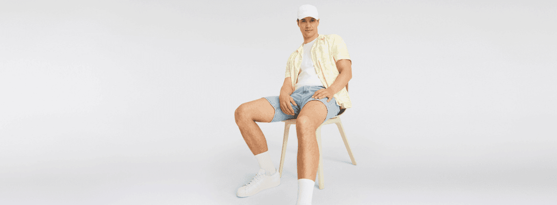 Man in korte broek op een stoel