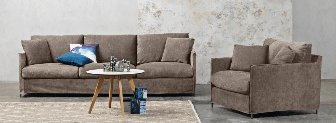 Woonkamer met een bank, stoel, vloekleed en salontafel erin