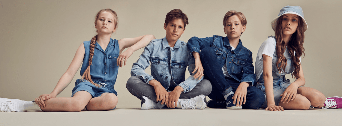 Vier kinderen op de grond die denim dragen