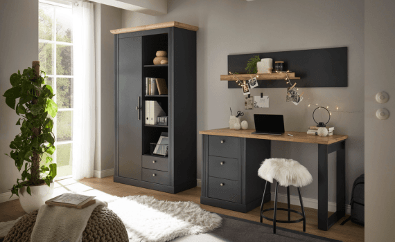 Een kleine kamer met een kast en een bureau waar een laptop op staat