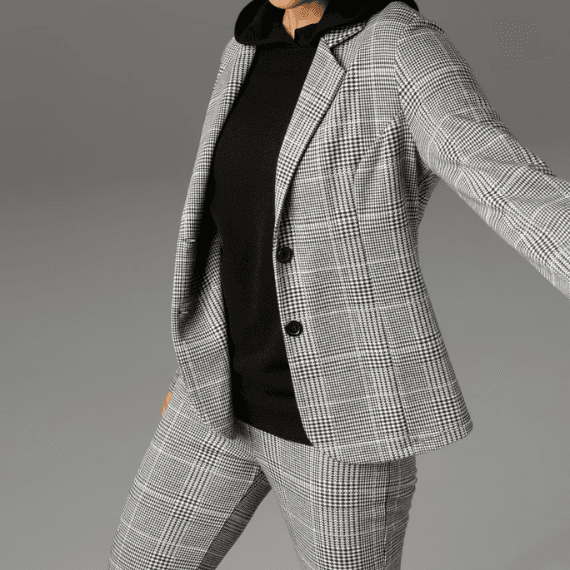 Vrouw met een grijze pantalon en blazer aan