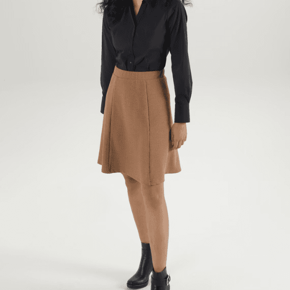 Vrouw met een zwart blouseje aan en een bruine rok eronder