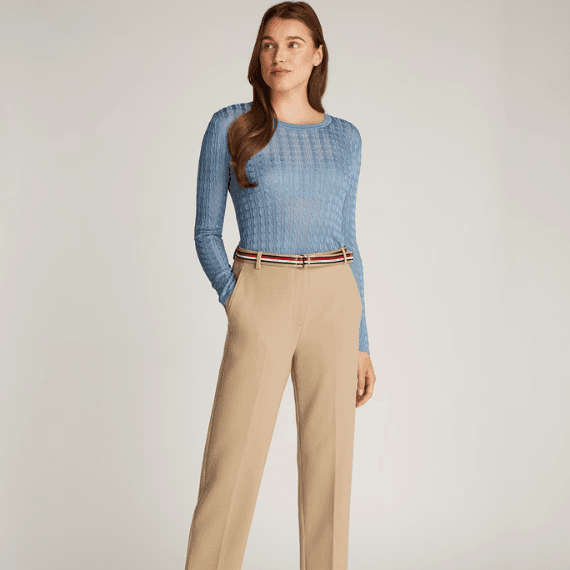 Een vrouw met een klassieke beige pantalon aan