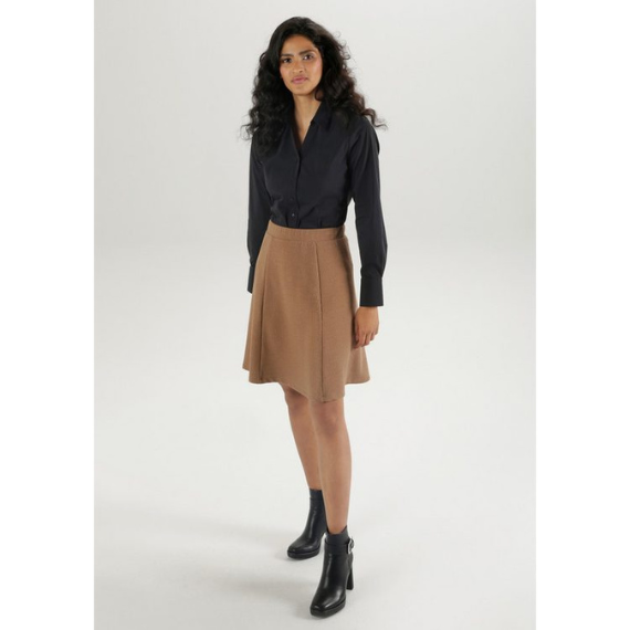 Vrouw met min A-lijn rok en zwarte blouse