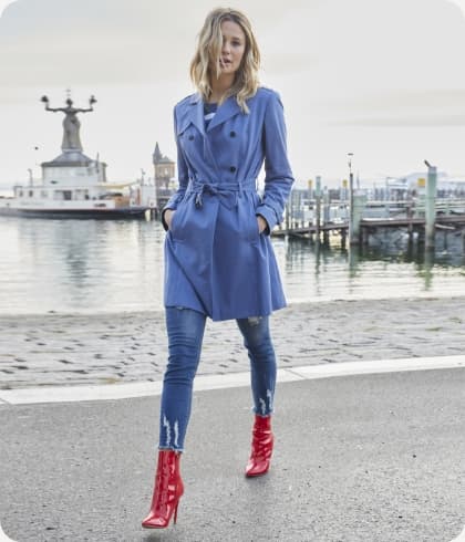 Vrouw in de haven met blauwe trenchcoat