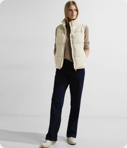 Staande vrouw met een witte bodywarmer aan