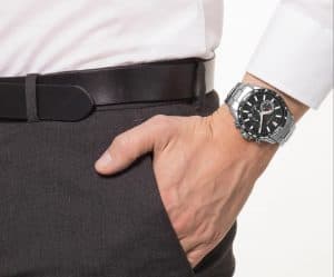 Man met een hand in de zak en een horloge om de pols